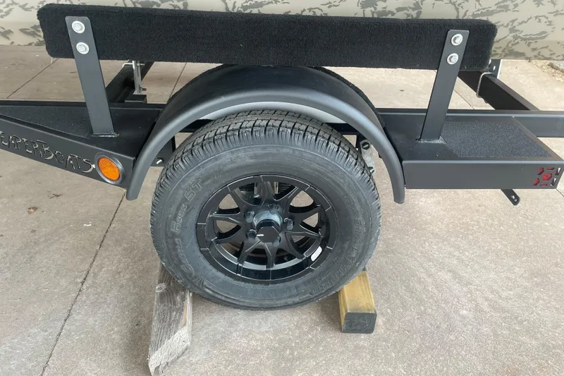 Slide: The Image of Trailer wheel of 2026 Reaper Boats 653 Timber Reaper, featuring black alloy rims. - 7