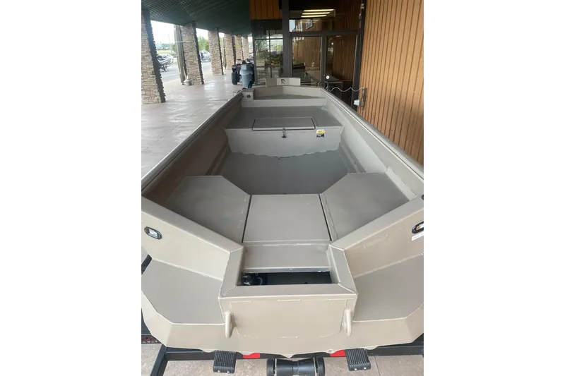 Slide: The Image of 2026 Reaper Boats 653 Timber Reaper, beige interior, displayed outdoors under a covered area. - 9