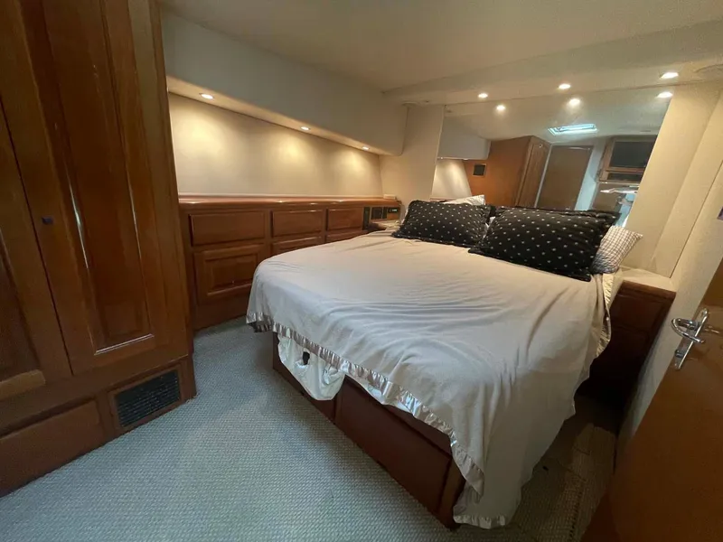 Slide: The Image of Luxurious bedroom interior of 1998 Viking 50 Convertible yacht with cozy bed and wooden cabinetry. - 12