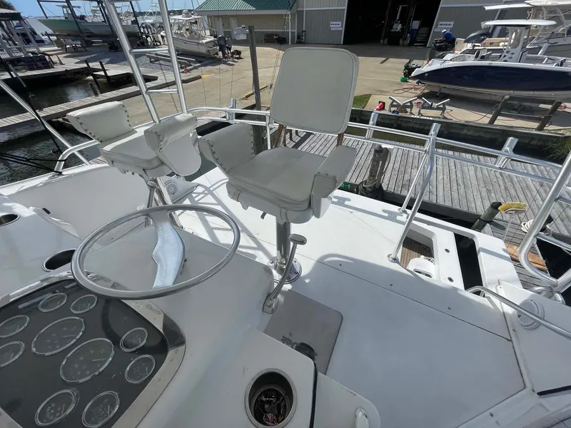 Slide: The Image of Helm of 1998 Viking 50 Convertible yacht with white captain chairs and control panel. - 23