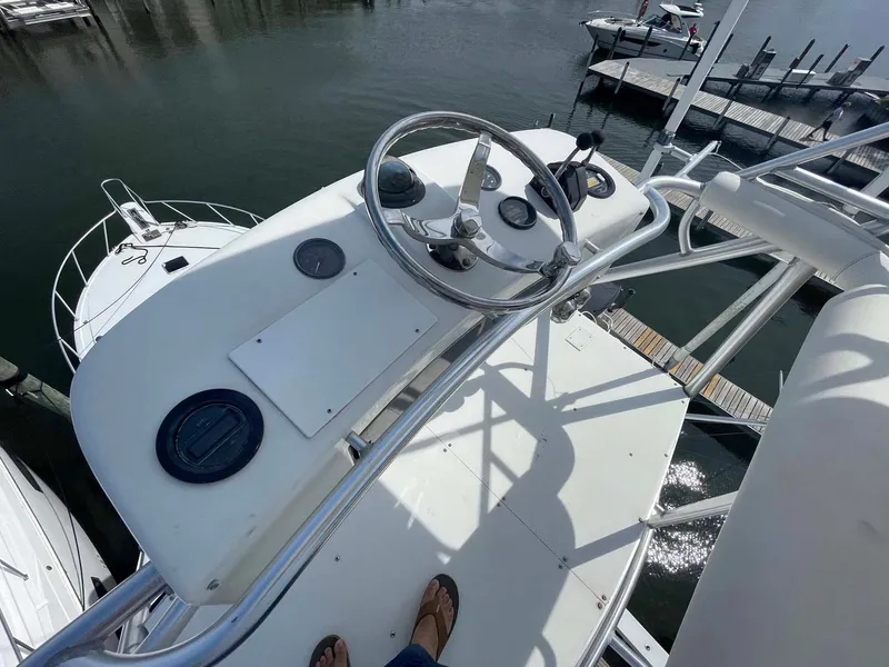 Slide: The Image of Helm of 1998 Viking 50 Convertible yacht with steering wheel and controls, docked at marina. - 24