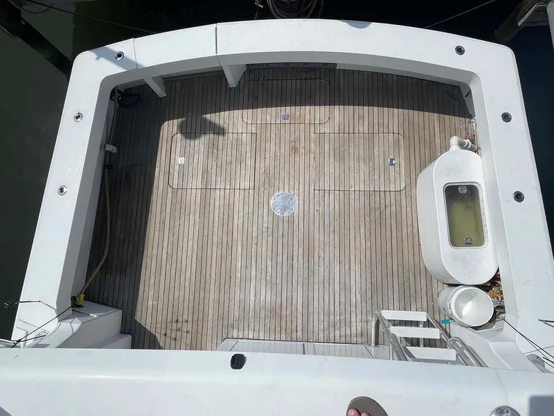 Slide: The Image of 1998 Viking 50 Convertible boat deck with wooden flooring and fishing equipment. - 30