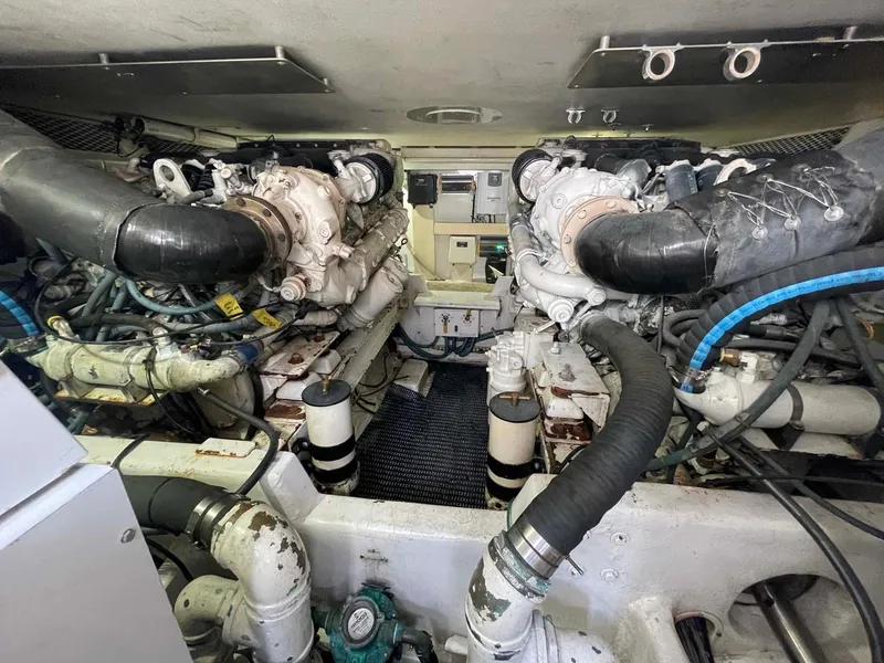 Slide: The Image of Engine room of a 1998 Viking 50 Convertible yacht, showcasing dual engines and mechanical components. - 34