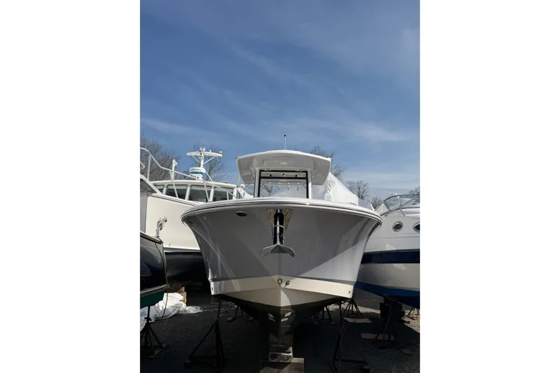 Slide: The Image of 2024 Robalo R250 Center Console boat on display under a clear blue sky. - 1