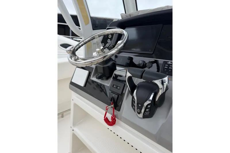 Slide: The Image of 2024 Robalo R250 Center Console helm with steering wheel and controls. - 10