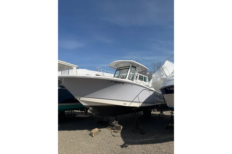 Slide: The Image of 2024 Robalo R250 Center Console boat on display under clear blue sky. - 2