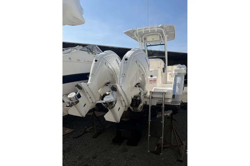 Slide: The Image of 2024 Robalo R250 Center Console boat with dual Yamaha outboard engines, docked outdoors. - 3