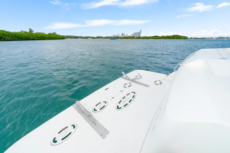 Slide: The Image of 2001 Cruisers Yachts 5000 Sedan Sport on serene water with city skyline. - 23