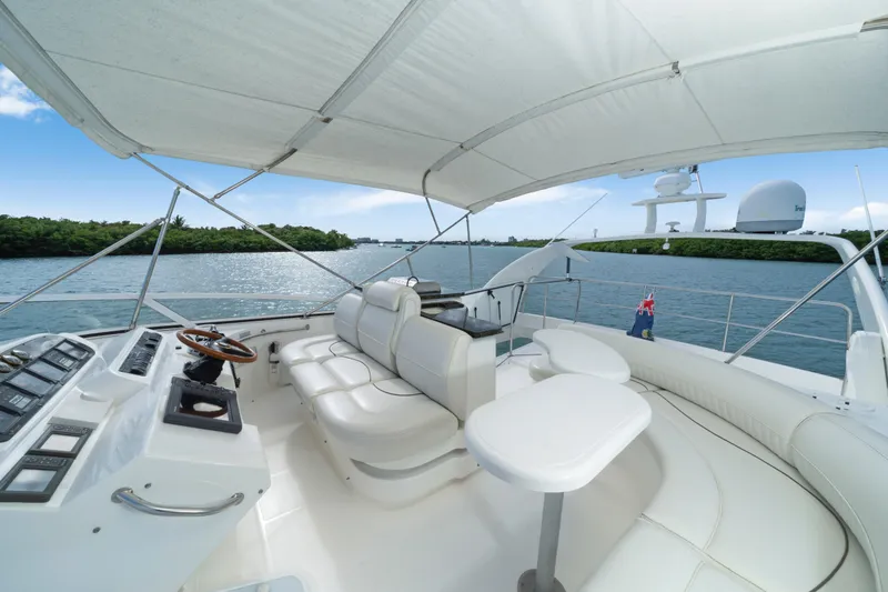 Slide: The Image of 2001 Cruisers Yachts 5000 Sedan Sport interior with white seating and helm, on calm water. - 25