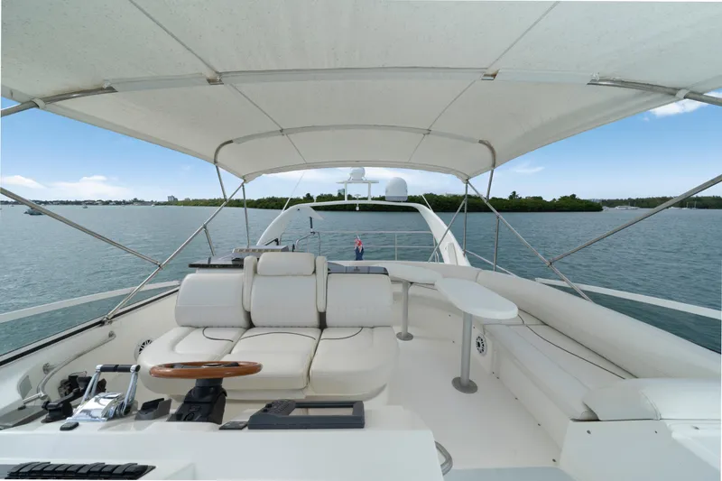 Slide: The Image of 2001 Cruisers Yachts 5000 Sedan Sport, spacious deck with seating, canopy, and scenic water view. - 28