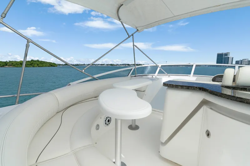 Slide: The Image of 2001 Cruisers Yachts 5000 Sedan Sport, luxurious deck view with seating and ocean backdrop. - 33