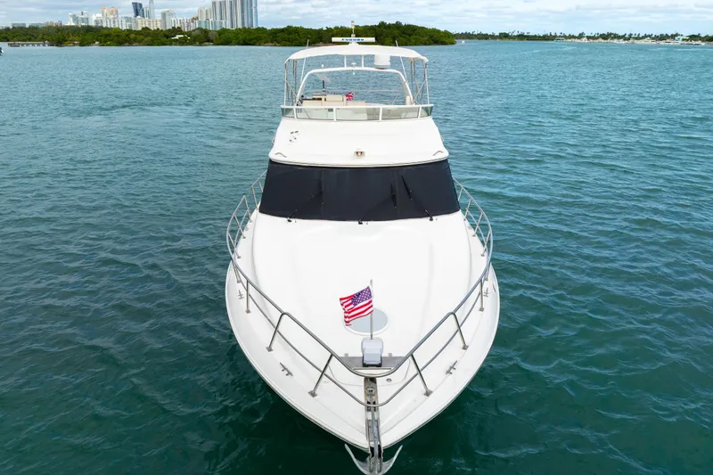 Slide: The Image of 2001 Cruisers Yachts 5000 Sedan Sport on open water, American flag displayed. - 4