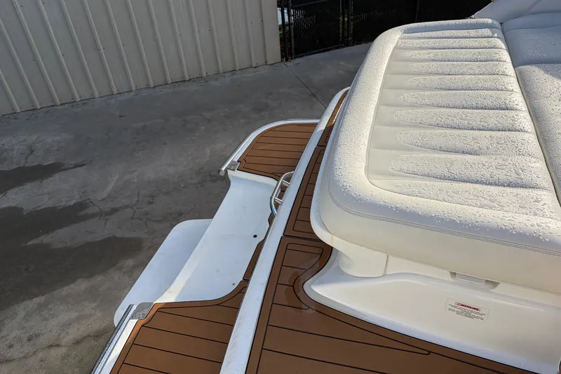Slide: The Image of 2015 Cobalt 336 boat with teak deck and cushioned seating, parked on concrete. - 12