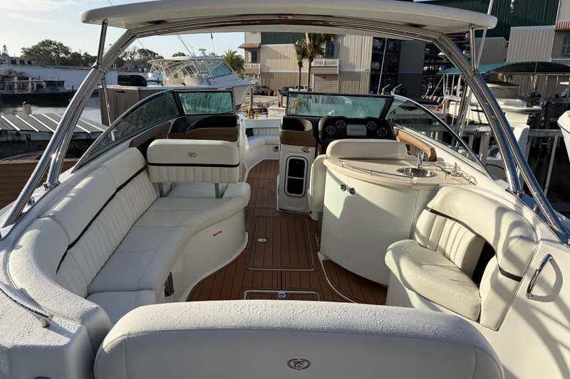 Slide: The Image of Luxurious 2015 Cobalt 336 boat interior with white seating and wooden flooring at a marina. - 16