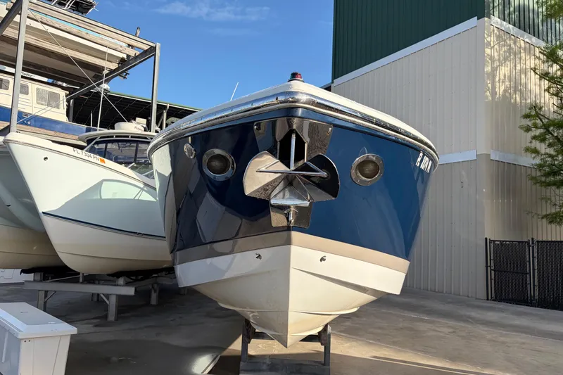 Slide: The Image of 2015 Cobalt 336 boat in storage, front view with blue hull and anchor. - 2