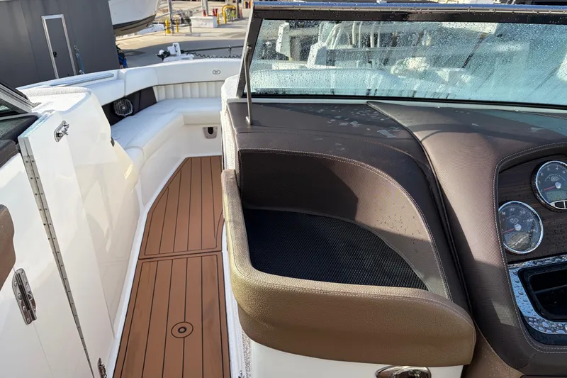 Slide: The Image of 2015 Cobalt 336 boat interior with brown seating, wooden flooring, and dashboard gauges. - 27