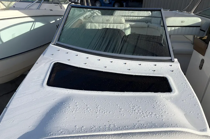 Slide: The Image of 2015 Cobalt 336 boat with wet deck and windshield, parked beside another vessel. - 33