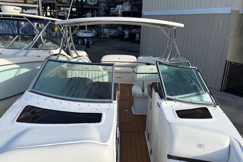 Slide: The Image of 2015 Cobalt 336 boat with white seating and sleek design in a marina setting. - 34