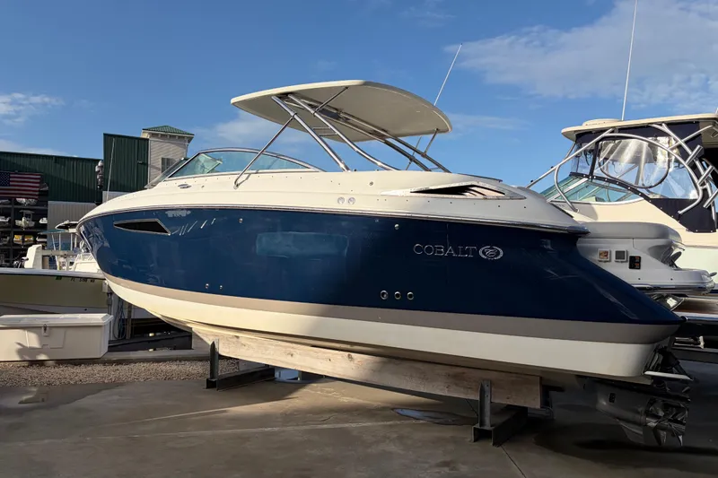 Slide: The Image of 2015 Cobalt 336 boat with blue hull on display at a marina. - 5