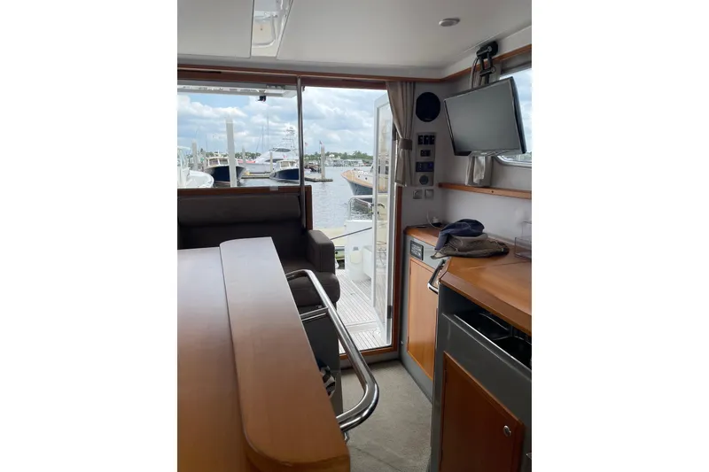 Slide: The Image of Interior view of 2015 Sargo 36 Flybridge yacht, featuring a cozy seating area and marina view. - 23