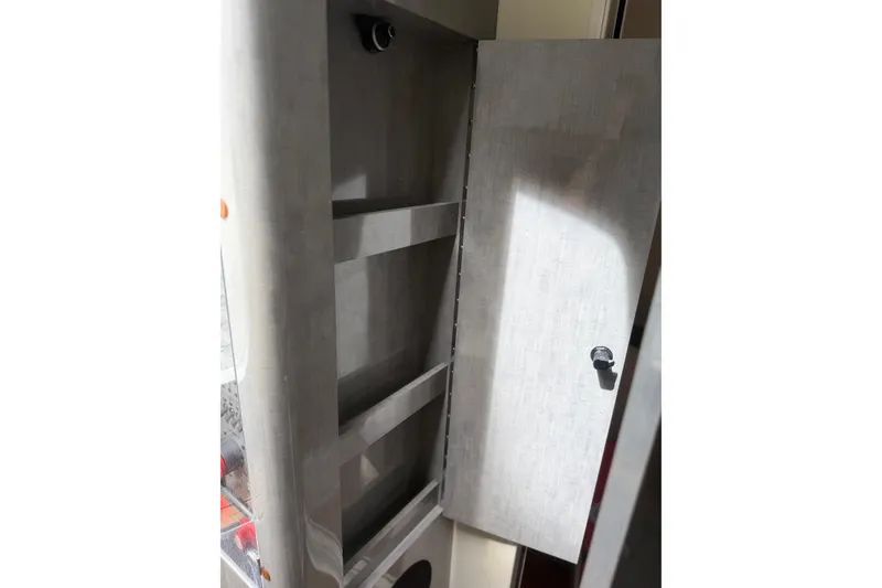 Slide: The Image of Open storage cabinet inside 2017 HCB 53 Suenos boat, featuring shelves and a door. - 52