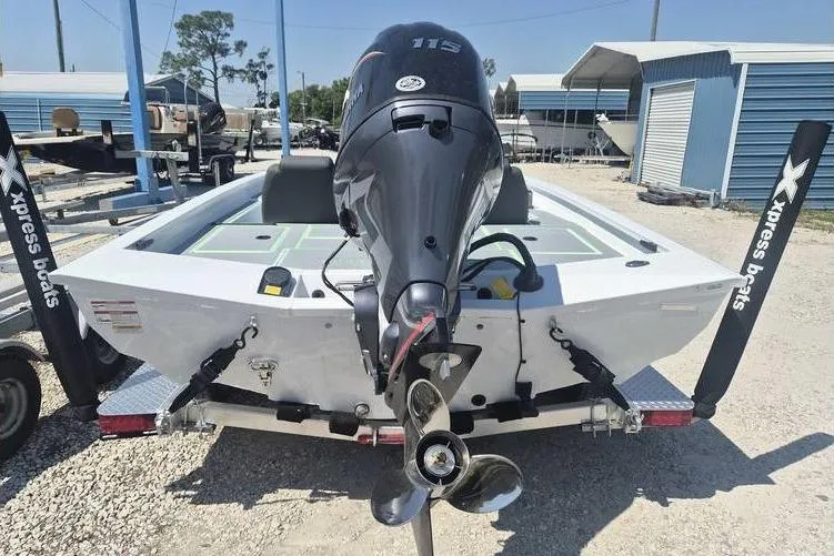 Slide: The Image of 2026 Xpress H18 boat with powerful outboard motor, displayed in a sunny marina setting. - 2