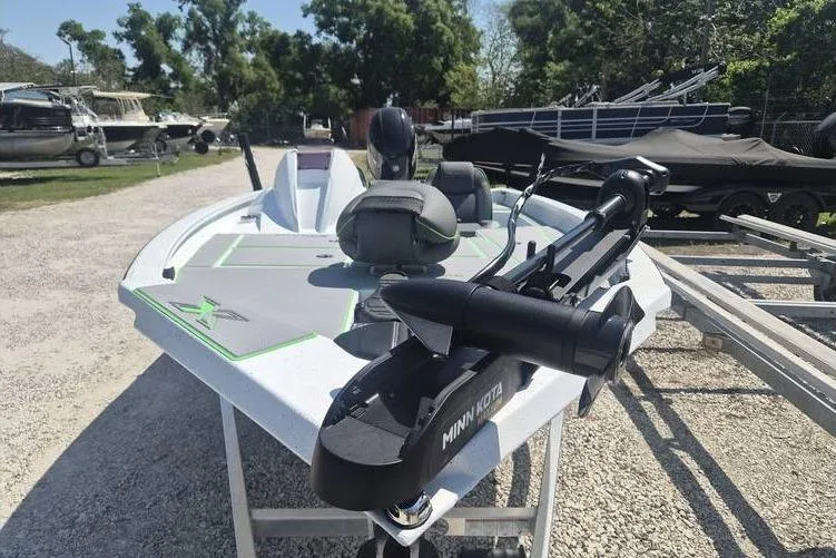 Slide: The Image of 2026 Xpress H18 boat with Minn Kota motor, parked outdoors on gravel. - 8