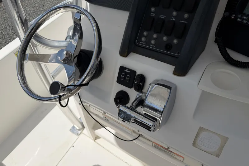 Slide: The Image of Steering console of a 2009 Boston Whaler 230 Dauntless boat, featuring controls and switches. - 13