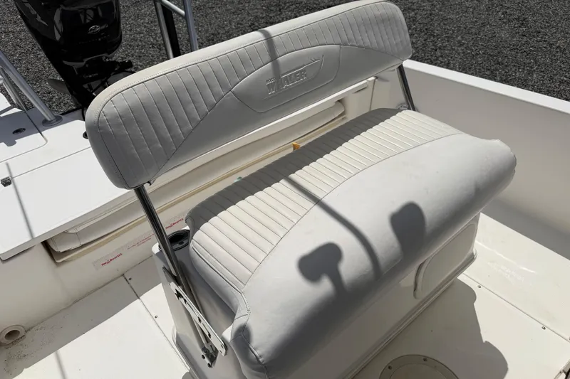 Slide: The Image of 2009 Boston Whaler 230 Dauntless boat seat with white upholstery and stainless steel frame. - 14