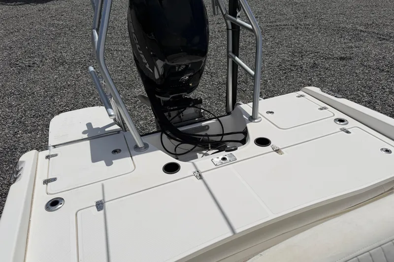 Slide: The Image of 2009 Boston Whaler 230 Dauntless boat deck with Mercury engine, shown on gravel surface. - 15