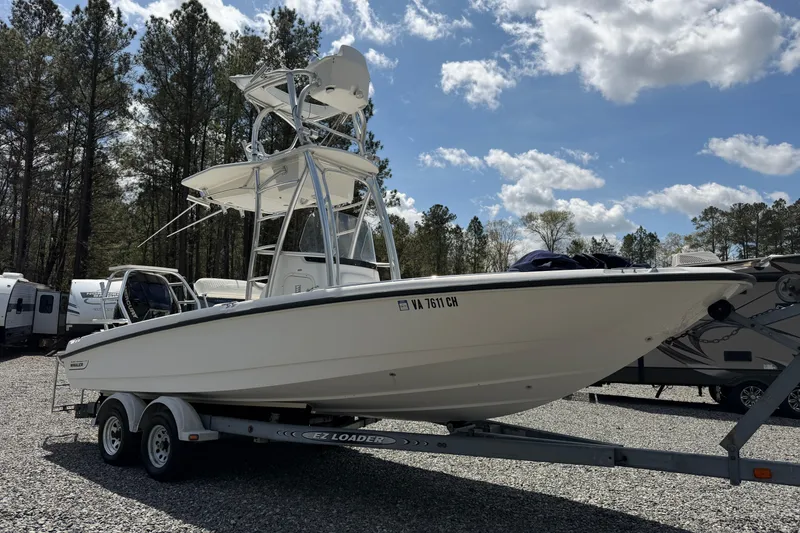 Slide: The Image of 2009 Boston Whaler 230 Dauntless boat on trailer, surrounded by trees and RVs. - 3