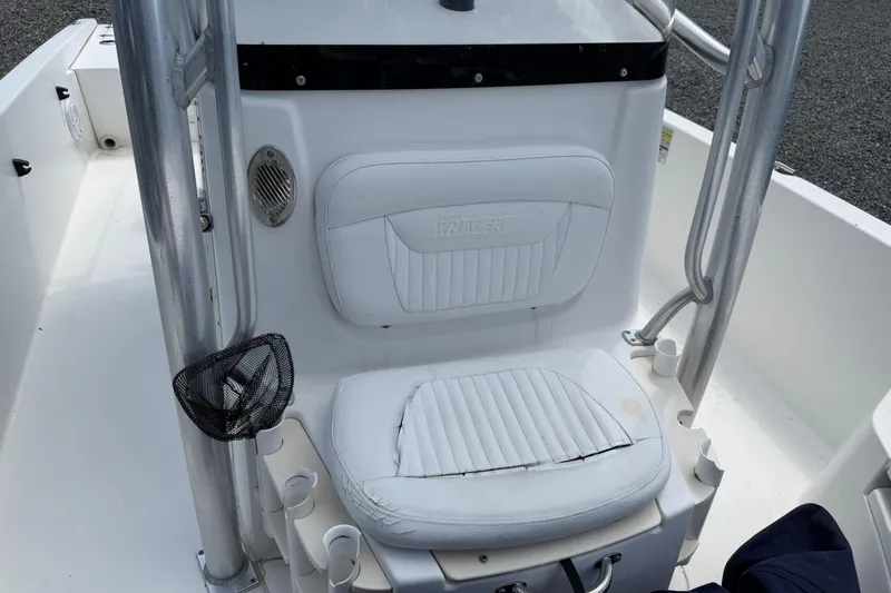 Slide: The Image of 2009 Boston Whaler 230 Dauntless boat seat with white upholstery and stainless steel frame. - 5