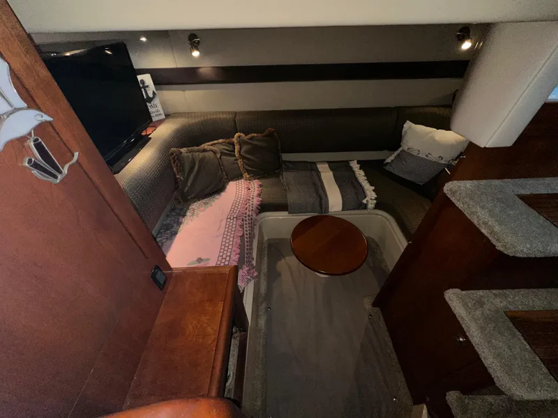 Slide: The Image of 2005 Cruisers Yachts 340 Express interior with cozy seating and wooden accents. - 6