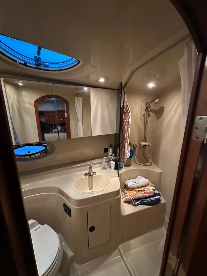 Slide: The Image of 2005 Cruisers Yachts 340 Express bathroom with sink, shower, and porthole window. - 8