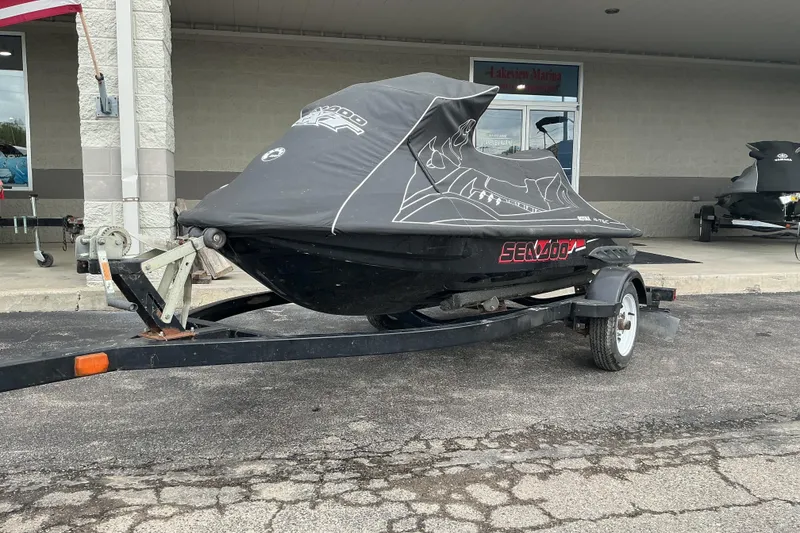 Slide: The Image of 2007 Sea-Doo RXT 215 jet ski on trailer, covered, parked outside a building. - 10