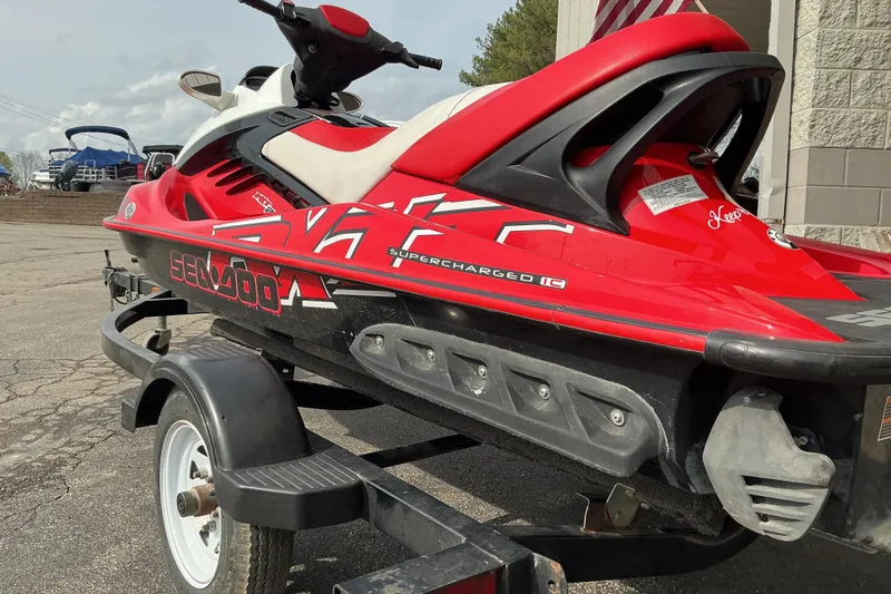 Slide: The Image of 2007 Sea-Doo RXT 215 jet ski in red, on a trailer, parked outdoors. - 3