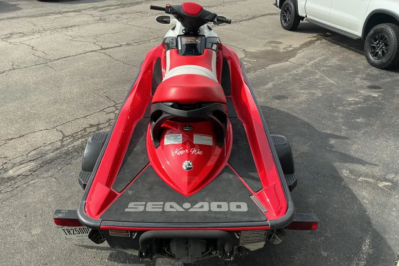 Slide: The Image of 2007 Sea-Doo RXT 215 jet ski on trailer, red and white design, parked on asphalt. - 5