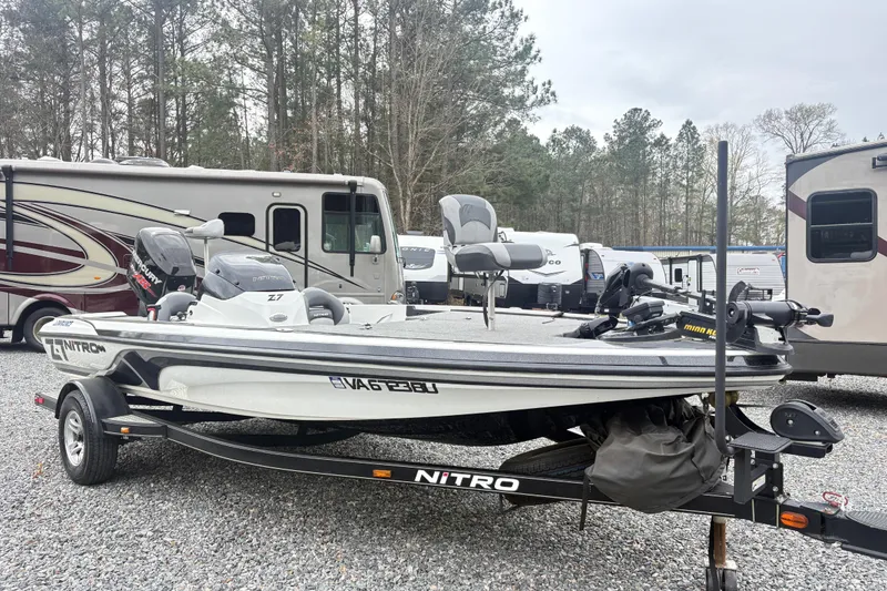 Slide: The Image of 2013 Nitro Z-7 boat on trailer, parked near RVs in wooded area. - 5