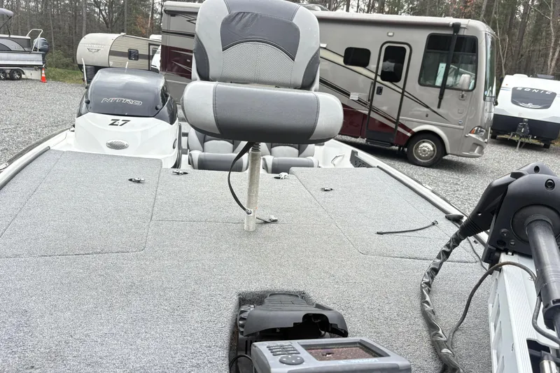 Slide: The Image of 2013 Nitro Z-7 boat with seating and motor, parked near RVs and trailers. - 9
