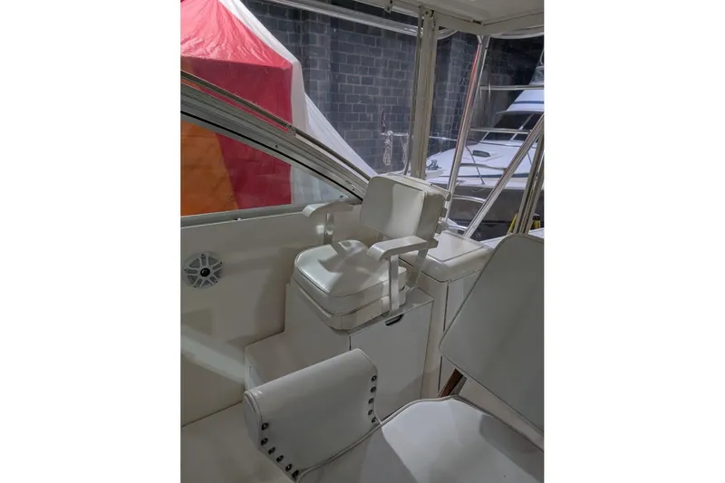 Slide: The Image of Interior of 2007 Rampage 38 Express boat with white seating and helm area. - 2