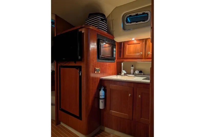 Slide: The Image of 2007 Rampage 38 Express yacht interior with kitchenette, wooden cabinets, and modern amenities. - 5