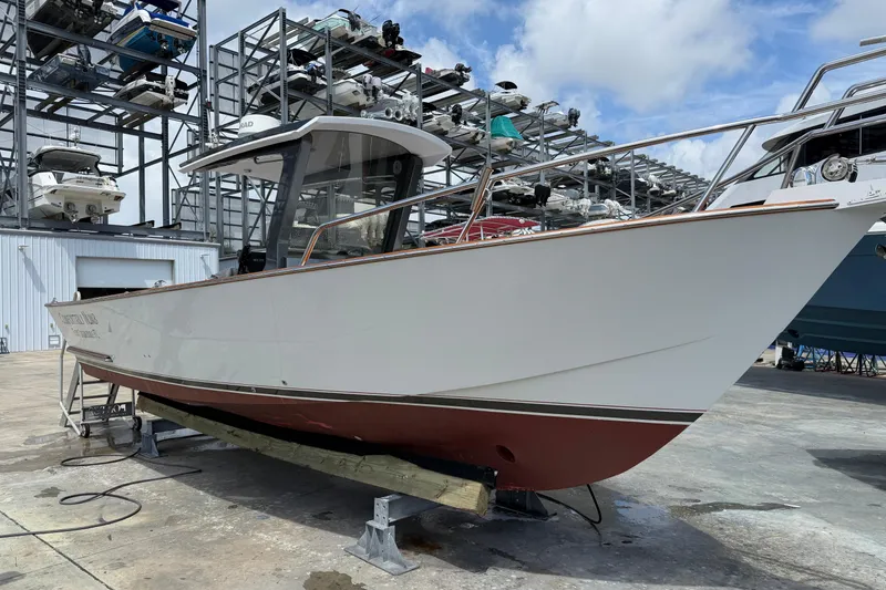 The Image of Custom 2013 Jet Center Console boat on dry dock, surrounded by stacked boats under a blue sky. - 0