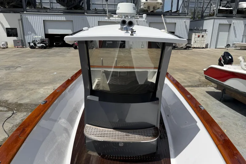 Slide: The Image of 2013 Custom Jet Center Console boat with wooden trim, docked at a marina. - 10