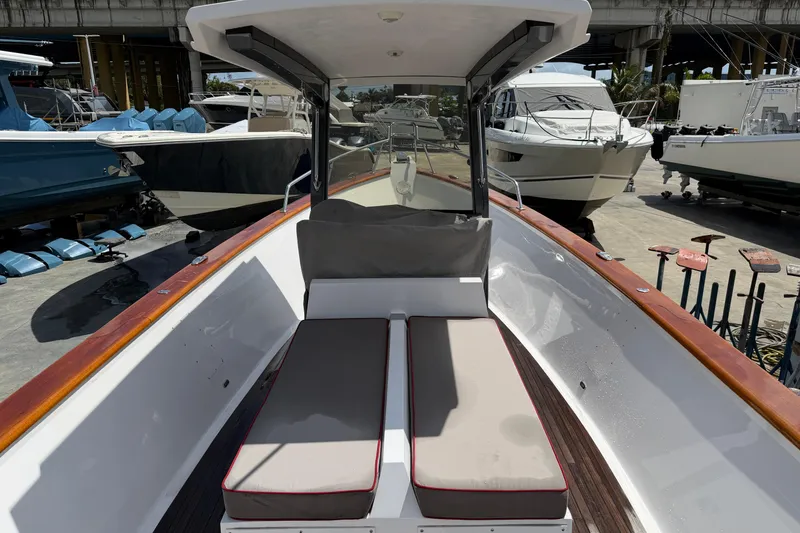 Slide: The Image of 2013 Custom Jet Center Console boat with cushioned seating, docked among other vessels. - 14