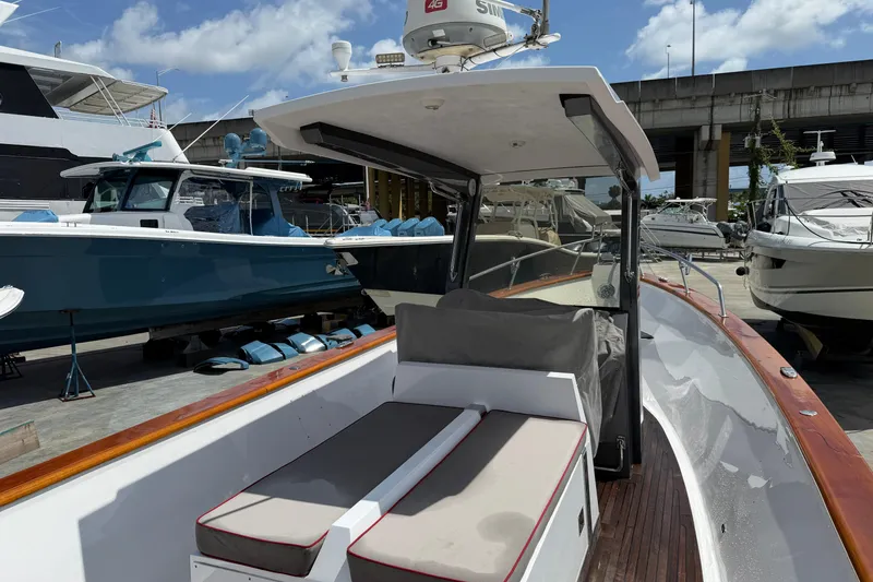 Slide: The Image of Custom 2013 Jet Center Console boat docked among other vessels under a clear sky. - 16