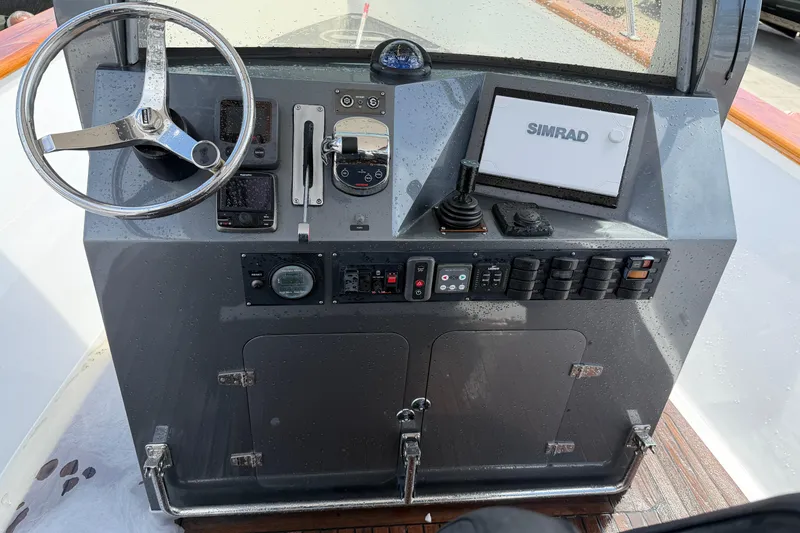 Slide: The Image of Control panel of a 2013 Custom Jet Center Console boat with steering wheel and Simrad display. - 24