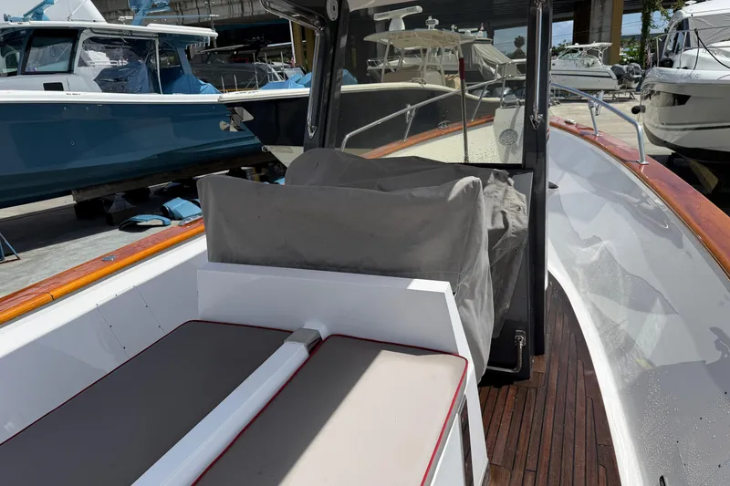 Slide: The Image of 2013 Custom Jet Center Console boat with covered seating and wooden deck in marina. - 7