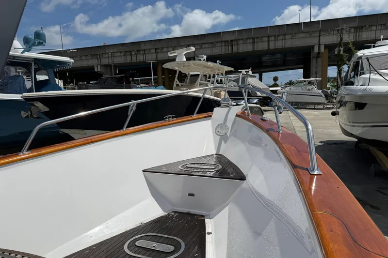 Slide: The Image of 2013 Custom Jet Center Console boat docked, featuring sleek design and polished wood accents. - 8