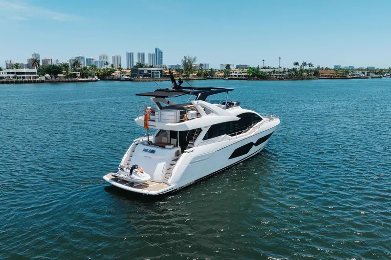 Slide: The Image of Luxurious 2022 Sunseeker 76 Yacht cruising on a serene waterway with city skyline backdrop. - 11