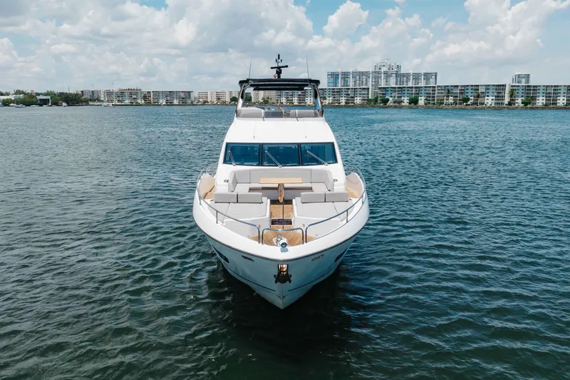 Slide: The Image of Sunseeker 76 Yacht 2022 on water, cityscape background, under cloudy sky. - 8